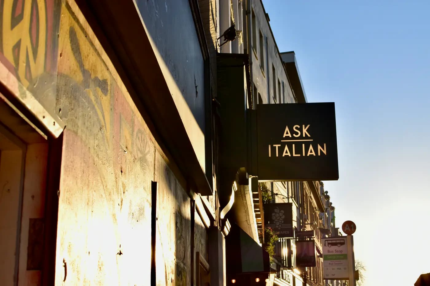 A restaurant storefront sign at golden hour