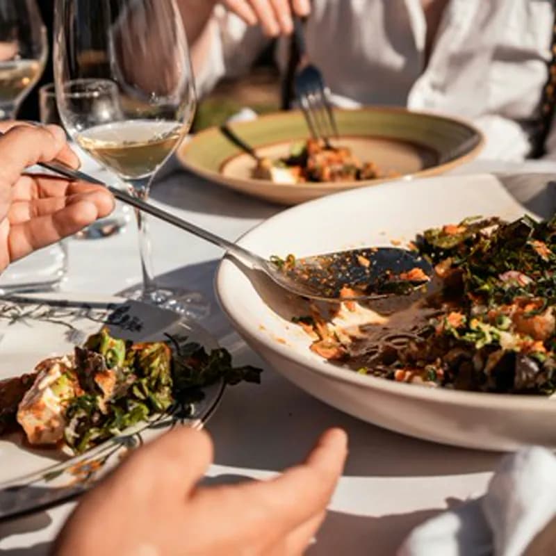 A group of people sitting at a table with plates of food