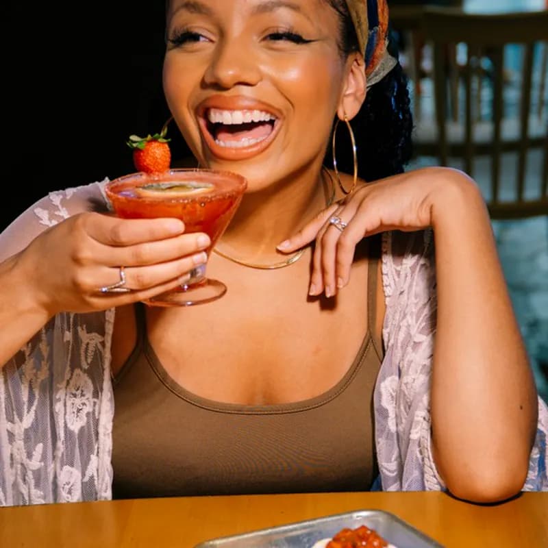 a woman sitting at a table with a plate of food